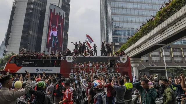 Pesepak bola Timnas Indonesia U-22 bersama ofisial dan pengurus PSSI berada di atas bus dalam arak-arakan Kira87uara Kontingen SEA Games 2023 saat melintas di Jalan Jenderal Sudirman, Jakarta, Jumat (19/5/2023). 