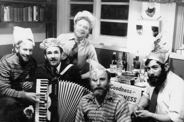 Fotografia em preto e branco que mostra cinco pessoas celebrando o Natal