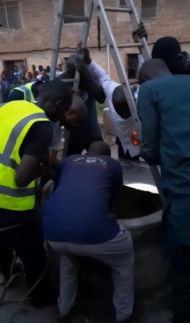 Àwọn òṣìṣẹ́ panápaná tó ń gbìyànjú láti yọ ìyá náà 