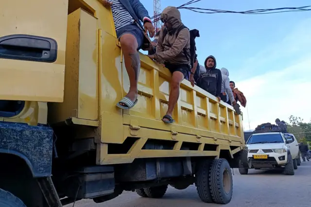 Sejumlah pria diangkut dengan truk.