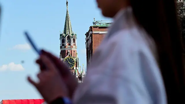 Жінка користується мобільним телефоном, прогулюючись поблизу Червоної площі в столиці Росії Москві 3 травня 2026 року.
