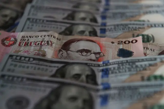 Billetes de dólares y pesos uruguayos
