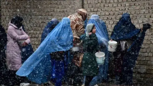 شماری از زنان مهاجر زیر بارش برف