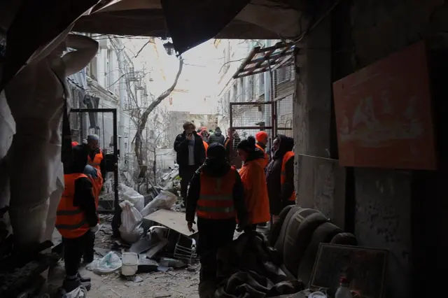 Комунальники прибирають завали у дворі пошкоджених будівель після обстрілу в Одесі 13 грудня 2025 року