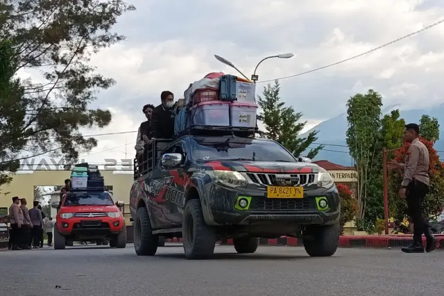 Kerusuhan di Papua. Sebuah mobil membawa barang-barang di atapnya.