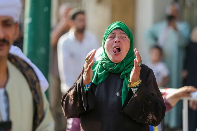 امرأة تطلق الزغاريد بينما يسير أعضاء من الطرق الصوفية الإسلامية خلال احتفالات رأس السنة الهجرية في 26 يونيو 2025 في القاهرة، مصر