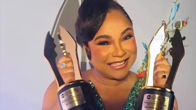 Linda Ejiofor mu ikanzu ishashagirana y'ubururu ateruye ibihembo bye