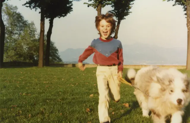 Старе фото - хлопчик з собакою біжить у парку 