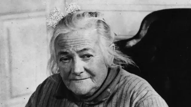 Une photographie en noir et blanc représentant Clara Zetkin, regardant vers l'appareil photo.