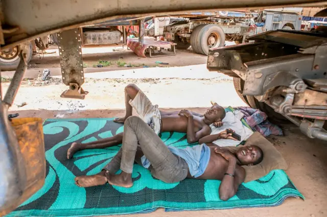 Des camionneurs couchés sous leur camion