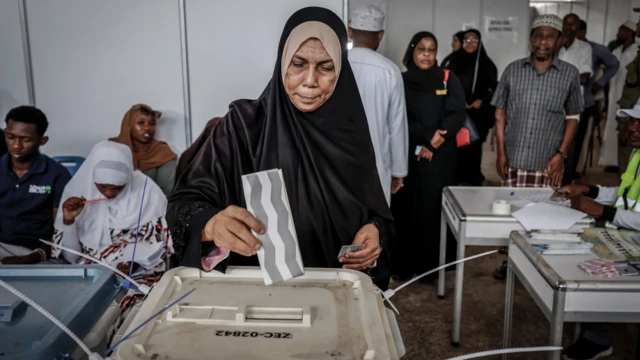 Obìnrin tó wọ hìjáàbù dúdú, tó ń fi ìbò rẹ̀ sínú àpótí ìbò 