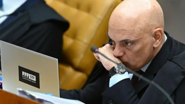 Alexandre de Moraes olha para computador em sessão do STF