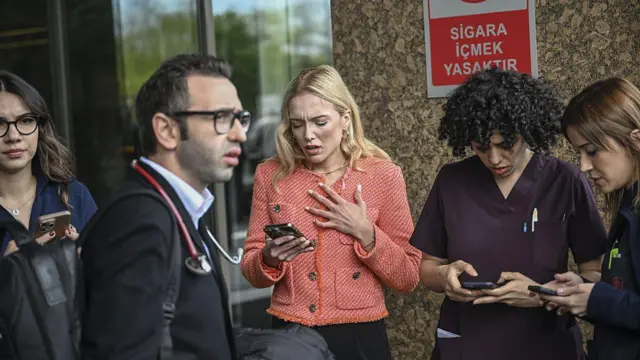 İstanbul Florence Nightingale Hastanesi'nin girişinde, endişeli kadın ve erkekler, telefonla yakınlarına ulaşmak için arama yapmaya çalışıyor