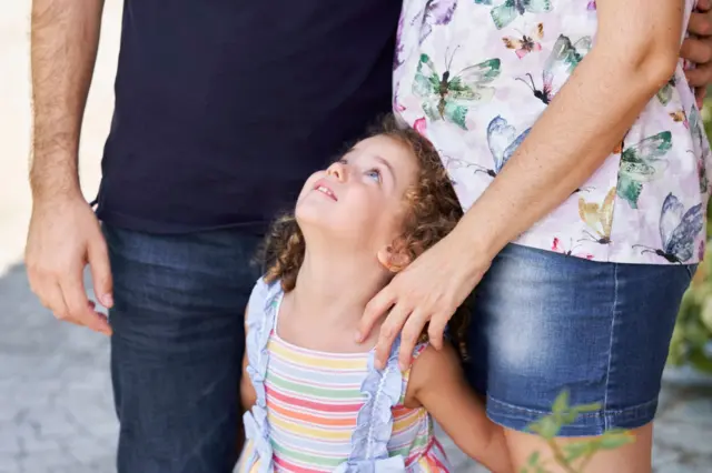 Enfant avec la tête tournée vers le haut, regardant ses parents