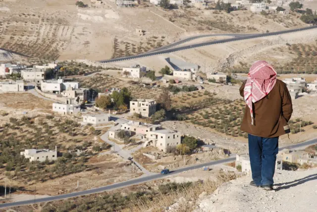 يقف فلسطيني فوق قرية على مشارف مدينة بيت لحم بالضفة الغربية.