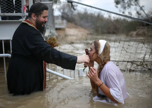 Православна верница учествује у церемонији поновног оживљавања Христовог крштења на обалама реке Јордан, за коју се верује да је место Исусовог крштења, на Богојављање близу Јерихона, на Западној обали коју је окупирао Израел
