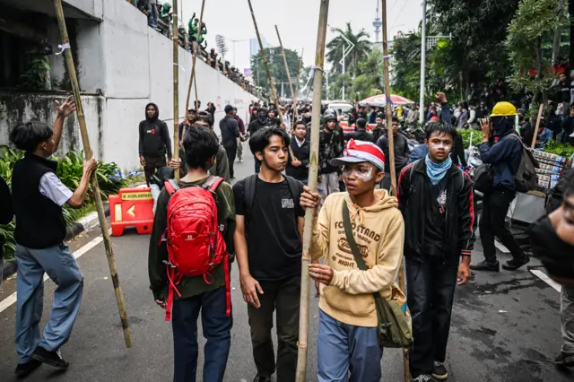 Sejumlah pengunjuk rasa membawa bambu saat melakukan aksi di Jalan Letjend S Parman, depan Gedung DPR, Jakarta, Senin (25/8/2025). 