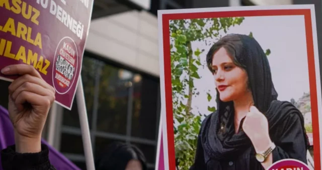 Wani ɗan zanga-zanga ke nan riƙe da hoton matashiya Mahsa Amini yayin wani maci a Turkiyya a watan da ya gabata