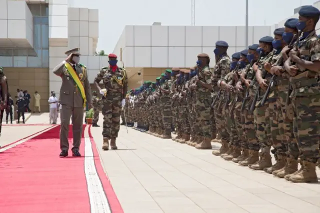 Le général Assimi Goïta (à gauche), salue les membres des Forces armées maliennes après sa cérémonie de prestation de serment à Bamako, le 7 juin 2021. 