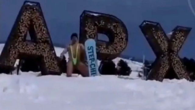 Homem praticando snowboardsportingbet saque pixuma encosta com um "mankini" estilo Borat