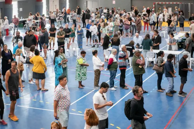 Des Français dans un fil d'attente pour aller voter