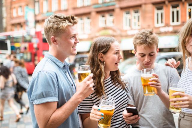 Un grupo de jóvenes bebiendo cerveza en la calle