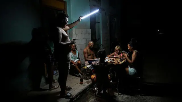 personas en cuba juegan dominó en la oscuridad. 