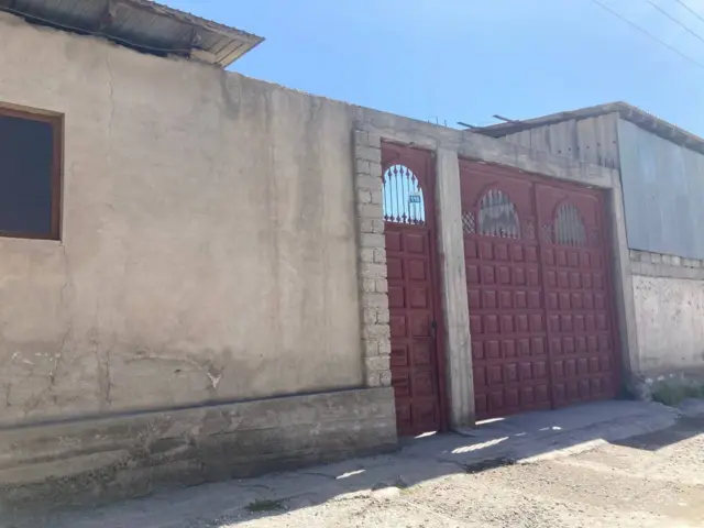 Brown metal gates in concrete wall of house where Muhammadsobir Fayzov lived