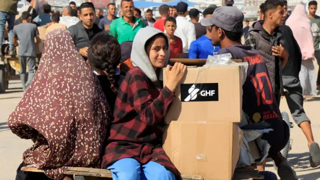Palestinians ride a donkey cart with boxes of aid from a distribution site run by the US-backed Gaza Humanitarian Foundation, in Rafah, in the southern Gaza Strip (27 May 2025)