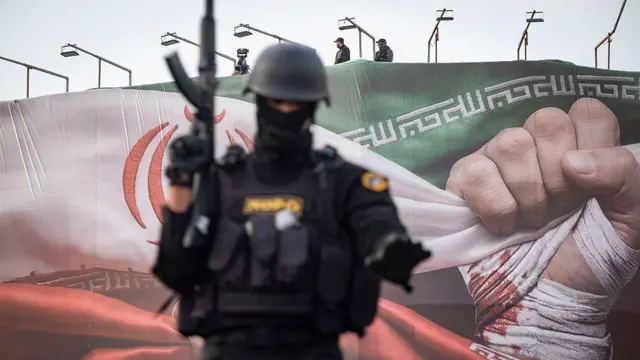 یک مامور یگان نوپو با لباس سیاه و کلاه‌خود و اسلحه‌ای در دست جلوی تصور دیده می‌شود. پشت سر او پلاکارد بزرگی با پرچم ایران و مشتی که زخمی به نظر می‌رسد دیده می‌شود. بالای پلاکارد که به نظر می‌آید روی نمای یک ساختمان نصب شده دو مامور نظامی دیده می‌شوند. در کنار آنها یک دوربین تلویزیونی قرار دارد.