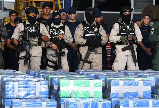 Policías de Costa Rica encapuchados frente a un alijo de drogas.