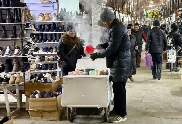 Qorasuv bozoridagi sotuvchi va xaridor.