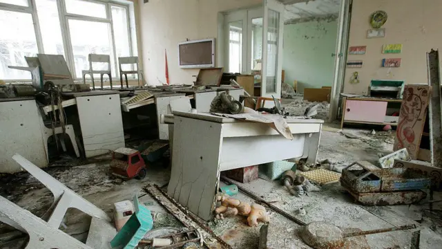 Escuela abandonada, en la que se ven las instalaciones destruidas y objetos rotos y desperdigados por el suelo. 