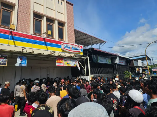 Petugas kepolisian menjaga minimarket.