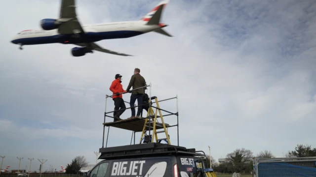 Dois homens observam avião pousando