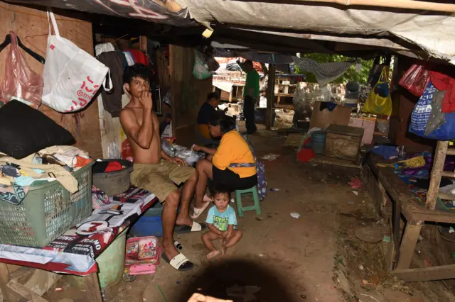 Seorang ibu menyiapkan makan untuk anaknya di rumahnya yang berdiri di bantaran Kali Ciliwung, Tanah Abang, Jakarta, Jumat (25/07/2025). 