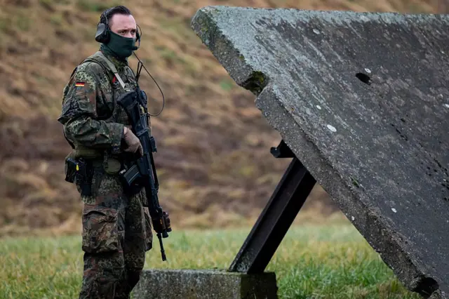 Silahlı ve kamuflajlı bir Alman askeri.