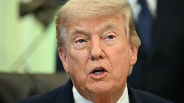 El presidente de EE.UU., Donald Trump, con un traje oscuro, una camisa blanca y una corbata roja

