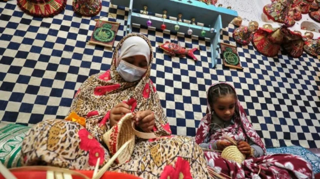 Wata mata da yarinya suna saƙa kwando a lokacin wani bikin al'ada a birnin Ghadames na Libya ranar Laraba...