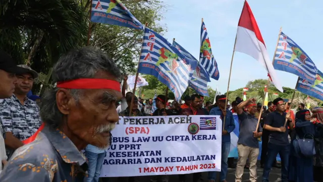 Sejumlah demonstran yang tergabung dalam Serikat Pekerja Aceh mengusung spanduk dan poster saat menggelar aksi damai memperingati Hari Buruh Internasional di Banda Aceh, Aceh, Senin (01/05). 