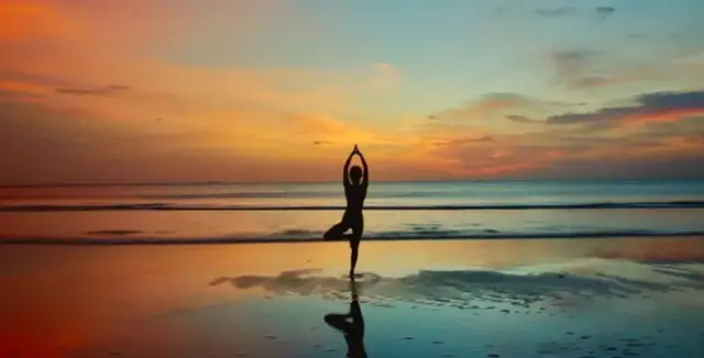 Pessoa faz ioga na praia