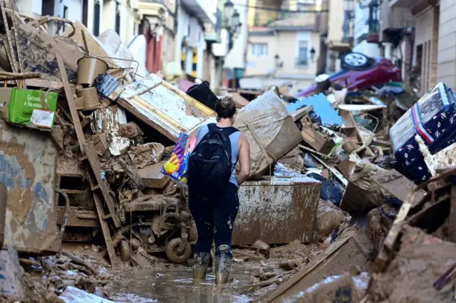 Una persona camina por una calle de Paiporta destrozada por la DANA.