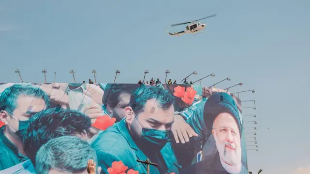 مراسم خاکسپاری رئیسی و هلیکوپتری بالای سر تشییعکنندگان