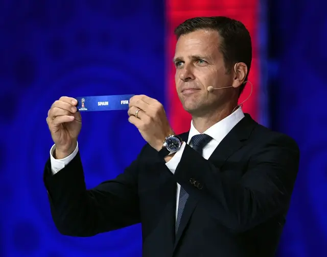 El exfutbolista Oliver Bierhoff sostiene el cintillo con el nombre de España durante un sorteo de la FIFA en 2018