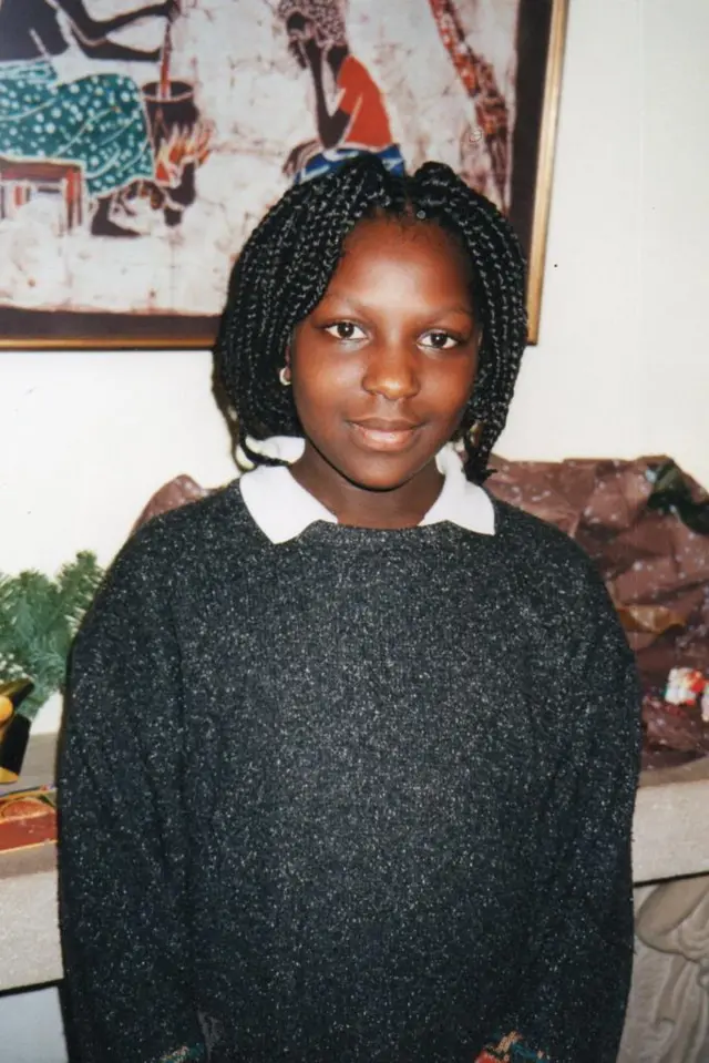 Marie, pose face caméra après première coiffure en salon Afro