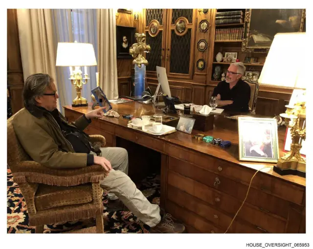 Steve Bannon, sentado en la silla de un despacho, dialoga con Jeffrey Esptein, que está al otro lado del escritorio