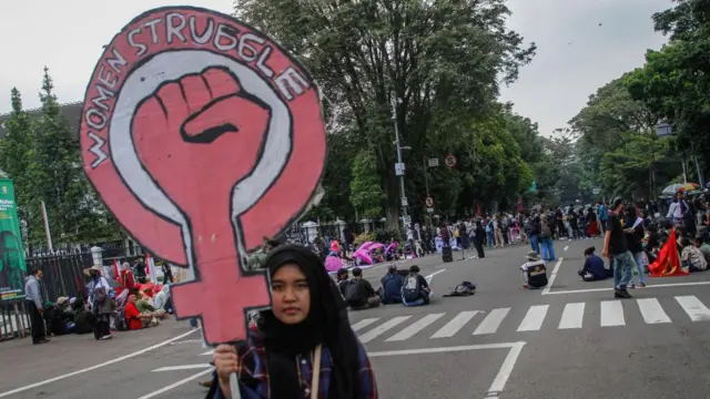 A woman hold a sign that reads 'women struggle' during a protest on International Women's Day 2022 in Indonesia