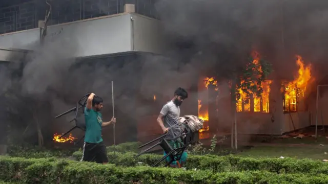 Люди выносят стулья из горящего музея Муджибура