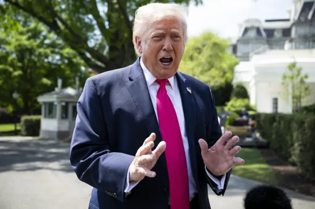 ホワイトハウスの屋外で記者団に話すスーツ姿のトランプ氏