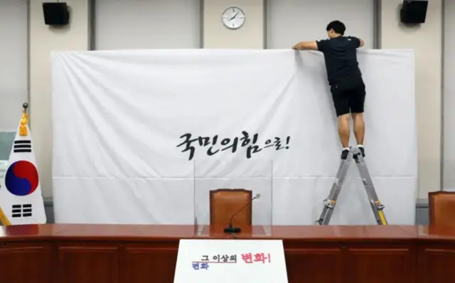 지난 2020년 3월 당명을 '미래통합당'에서 '국민의힘'으로 변경한 국민의힘 담당자가 서울 여의도 국회 당대표회의실의 백드롭 교체 작업을 하고 있다
